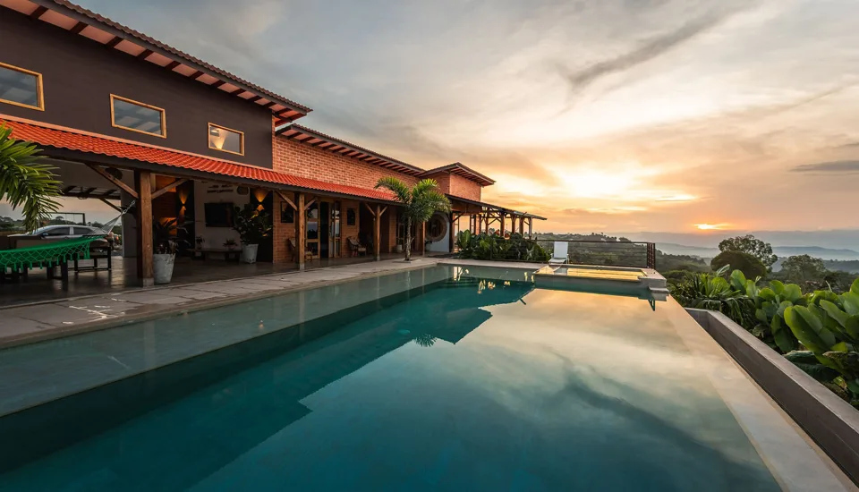 Piscina y fachada de arquitectura cafetera al atardecer